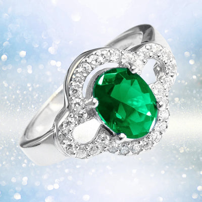 Godiva Ring featuring a sterling silver band with a large oval green gemstone centerpiece surrounded by smaller clear stones, designed for female jewelry enthusiasts.