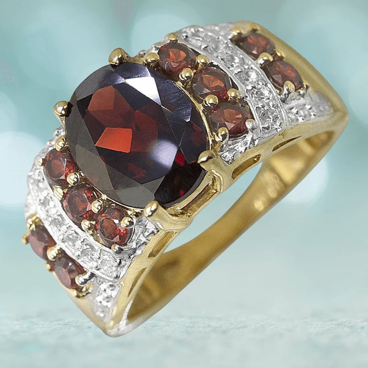 Marrakech Garnet Ring featuring a large oval garnet centerpiece surrounded by smaller garnet stones and sparkling accents, set in gold-plated sterling silver for women.