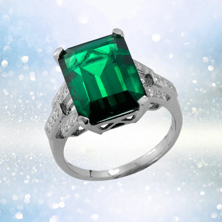 Hutton Ring featuring a large emerald-cut green gemstone set in sterling silver with rhodium plating, designed for women with intricate diamond-accented details.