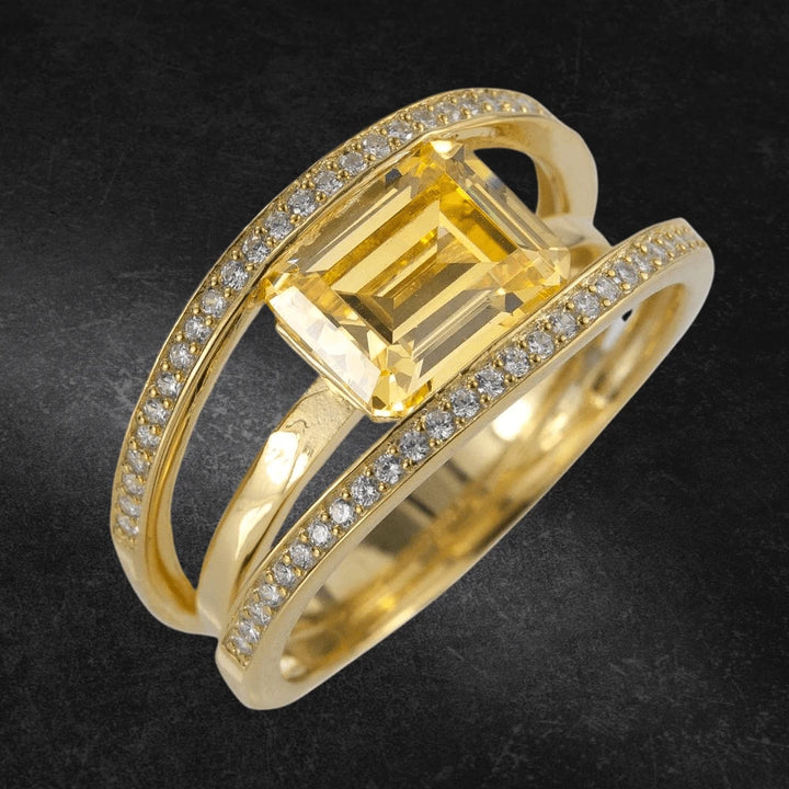 Canary Strata Ring featuring a gold-plated sterling silver band adorned with sparkling stones and a large rectangular yellow gemstone, designed for women’s jewelry collections.