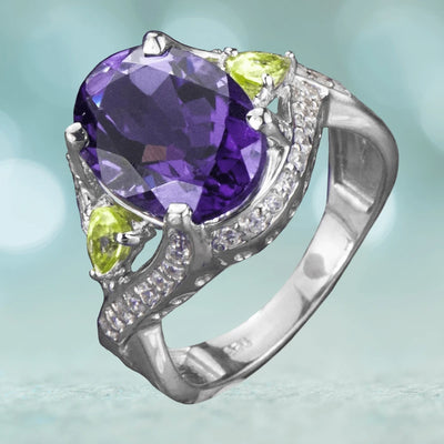 Kamira Amethyst Ring featuring a large oval amethyst center stone, accented by two pear-shaped peridot gemstones, set in sterling silver with rhodium plating for women’s jewelry.