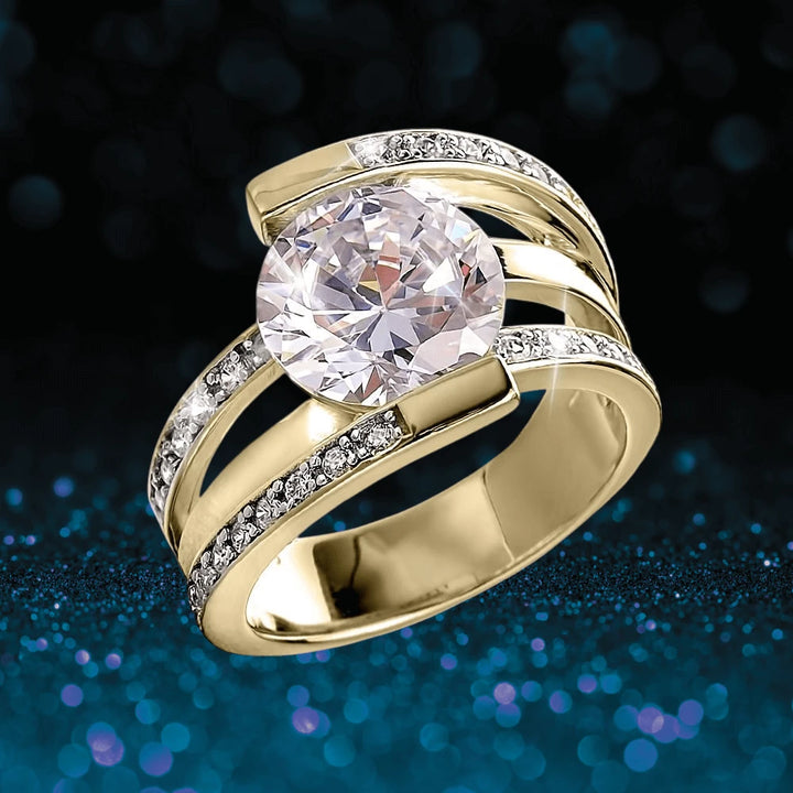 Rodela Gold Ring featuring a large sparkling center stone set in sterling silver with gold plating, accented by smaller clear stones, designed for female jewelry enthusiasts.