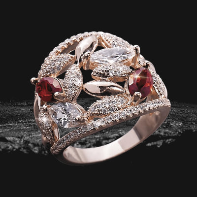 Fever Rose Ring featuring sterling silver with rose gold plating, adorned with sparkling clear and red gemstones set in an intricate floral-inspired design for women’s jewelry.