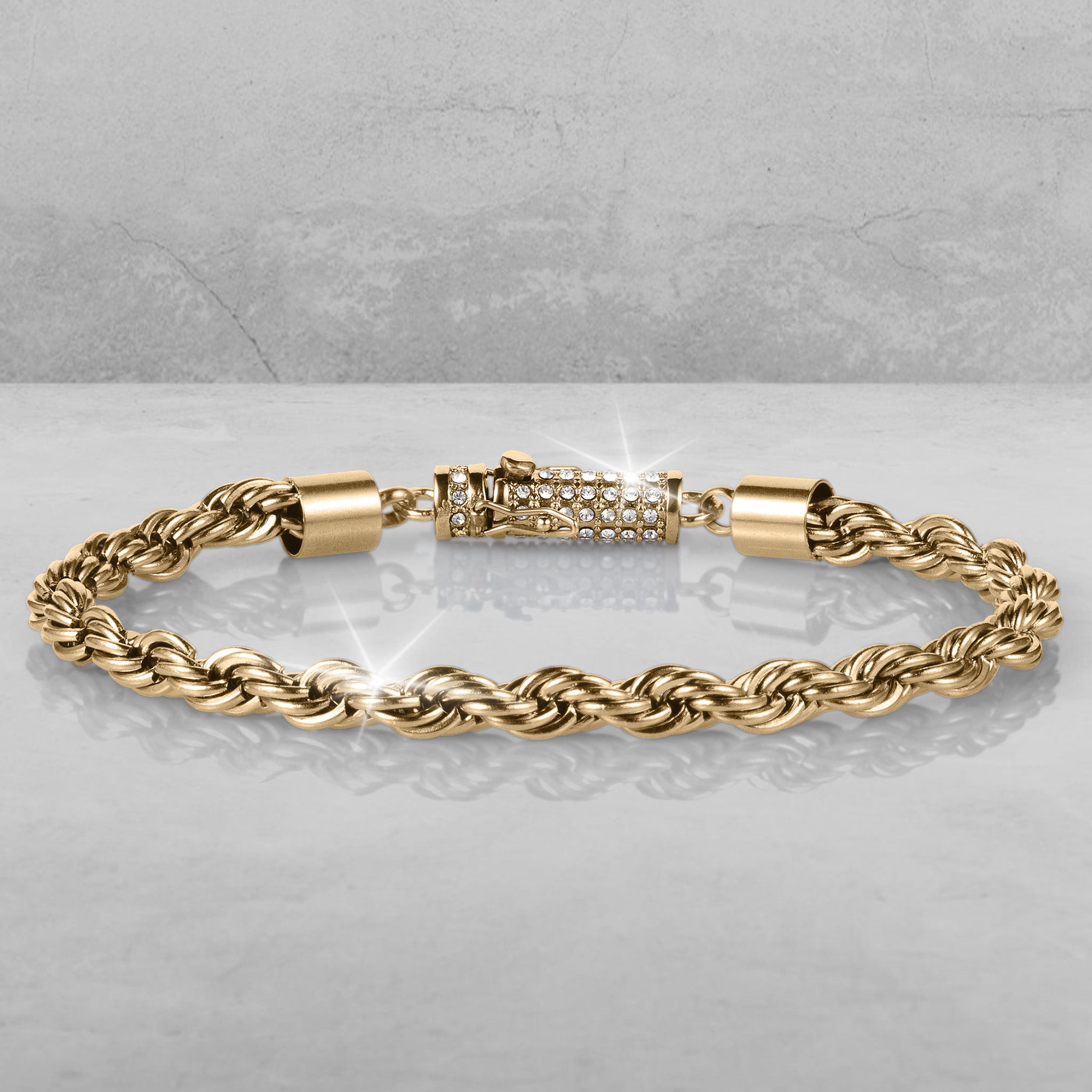 Viper Twist Rope Bracelet in gold tone with a braided rope design and sparkling jeweled clasp displayed on a reflective surface