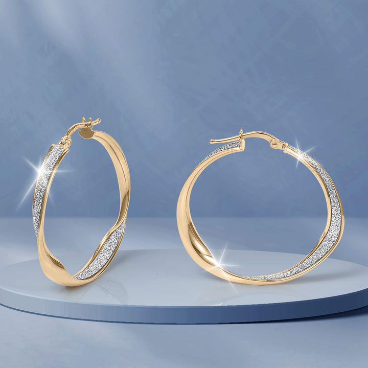 Serena Earrings gold hoop jewelry with sparkling pavé accents displayed on a blue pedestal for an elegant polished look and timeless style