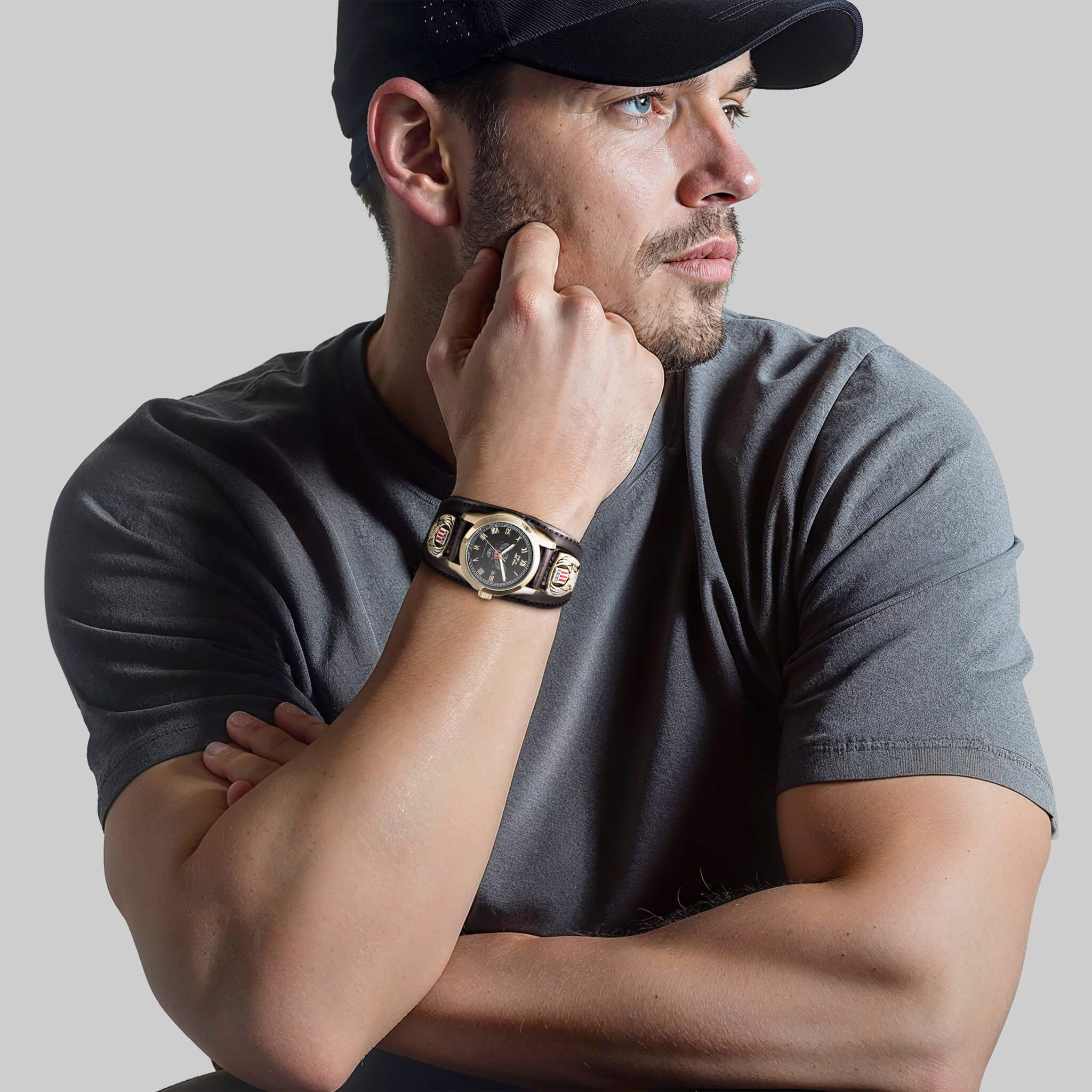 Man wearing a Patriot Men's Watch with stainless steel and gold plating, featuring a black dial, styled with a gray t-shirt and black cap.