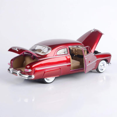 Model of a classic red car with open doors and hood on a white background
