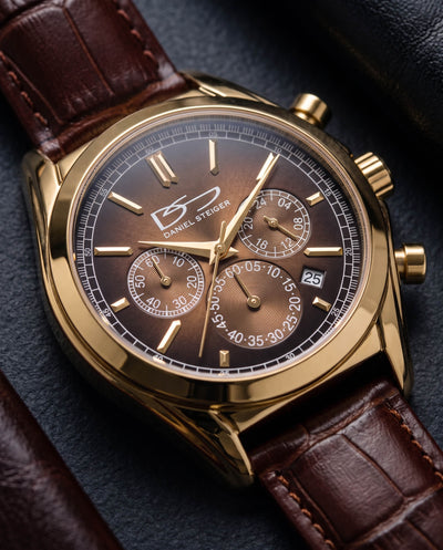 Gold-tone Daniel Steiger chronograph watch with a brown leather strap and dark brown dial featuring subdials and date window
