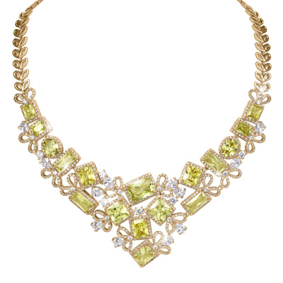Golden Willow Necklace with a gold tone leaf chain green gemstones and sparkling crystal accents arranged in an elegant botanical statement design