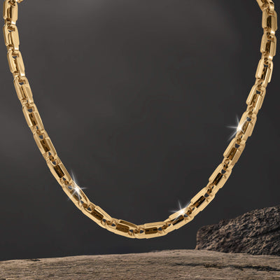 Moderna Link Necklace featuring a polished gold tone chain with rectangular links and sparkling accents against a dark background