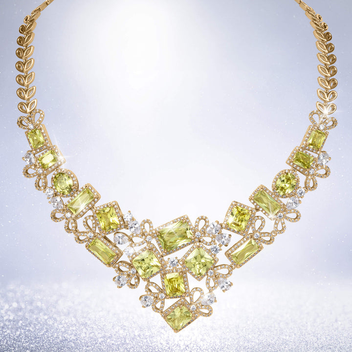 Golden Willow Necklace featuring a gold leaf chain with luminous green gemstones and sparkling clear crystal accents in an elegant statement design
