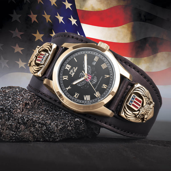 Luxury watch with American flag design on a dark surface with an American flag in the background