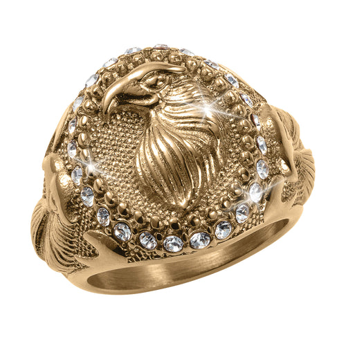 Gold ring with an eagle design and embedded crystals on a white background
