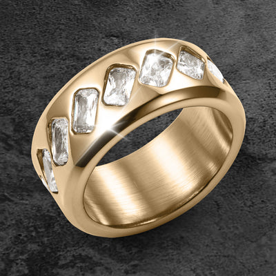 Tessera Men's Ring in gold tone with a curved band and rows of rectangular clear stones displayed on a dark textured surface