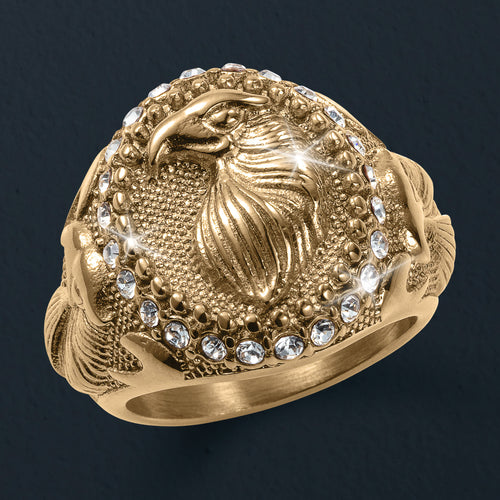 Gold ring with an eagle design and diamond accents on a dark background