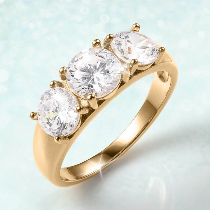 Serenata Trilogy Ring in polished gold featuring three brilliant round cut stones in a classic trilogy setting and elegant bands that symbolize lasting love
