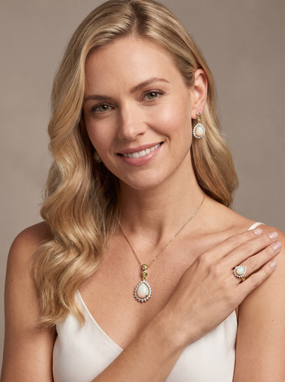 Opal Dew Drop Pendant showcased on a smiling woman wearing an elegant teardrop opal necklace with coordinating earrings and ring Up To 75% Off Retail