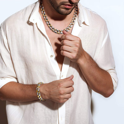 Man wearing a Curb Vine Men's Necklace made of two-tone stainless steel paired with a matching bracelet, styled with a white open-collar shirt.