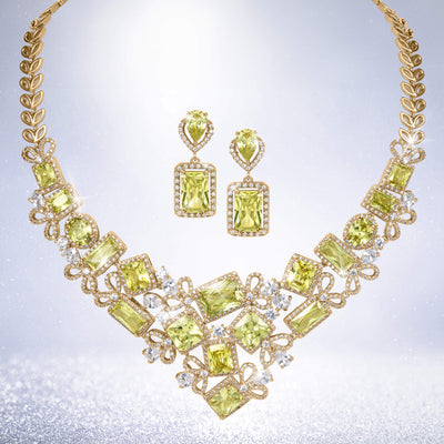 Gold tone necklace and matching drop earrings featuring sparkling lime green gemstones and crystal accents in an ornate statement jewelry set