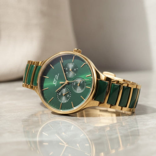 Green watch with gold band on a reflective surface. Daniel Steiger Verde Ceramic Men&