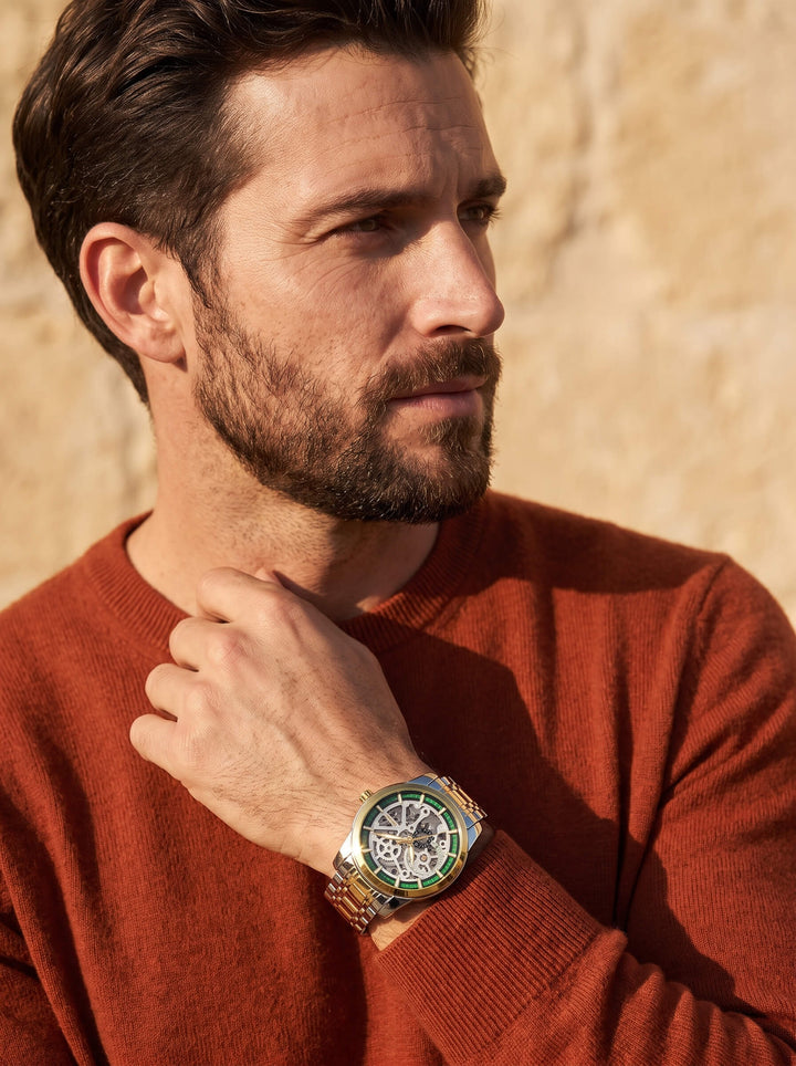 Heritage Skeleton Automatic Watch worn by a bearded man in a rust sweater with intricate exposed mechanics and Up To 75% Off Retail