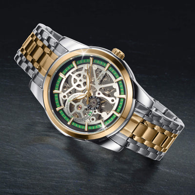 Two tone automatic skeleton watch with a green accented dial gold and silver bracelet displayed on a dark surface Up To 75% Off Retail