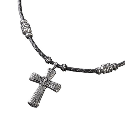 Midnight Skull Steel Pendant featuring a sterling silver cross design on a black braided leather necklace, crafted for men’s jewelry collections.