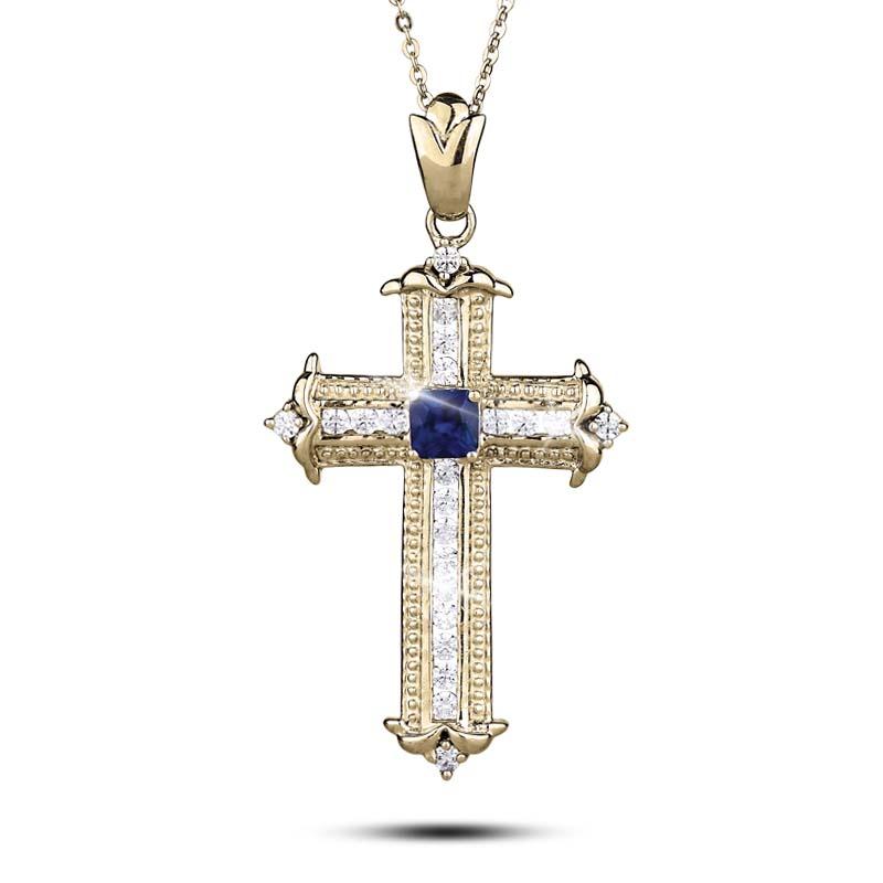 Sapphira Cross Pendant featuring a sterling silver cross plated in gold with a central blue gemstone and clear accent stones, designed for female jewelry lovers.