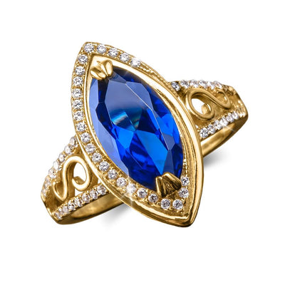 Ceylon Marquise Ring featuring a marquise-cut deep blue gemstone set in sterling silver with gold plating, adorned with small sparkling clear stones on an elegant band for females.