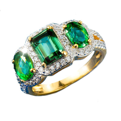 Fortuna Ring featuring three vibrant green gemstones set in sterling silver with gold plating, surrounded by sparkling small clear stones, a luxurious female jewelry piece.