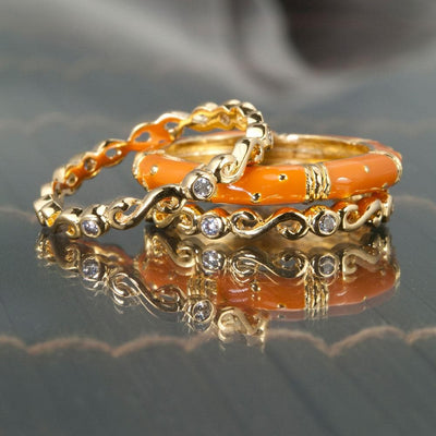 Three delicate gold rings with bright terracotta enamel and small clear stones, featuring the Ming Enamel Stacker Terracotta Rings made of sterling silver with gold plating for women.