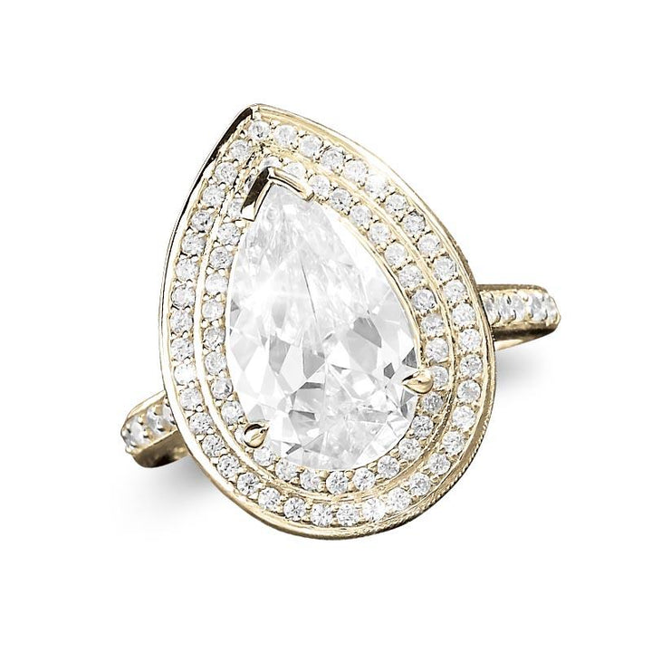 Pasha Pearshape Ring featuring a sterling silver band with gold plating, adorned with a large pear-shaped clear gemstone surrounded by two rows of smaller sparkling stones, designed for women.